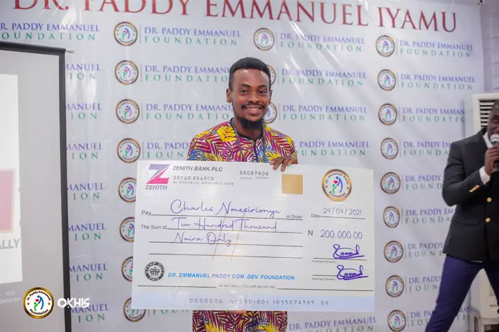A recipient with her cheque on stage