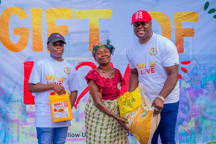 Dr Paddy Iyamu and a young volunteer presenting items at Gift of Love