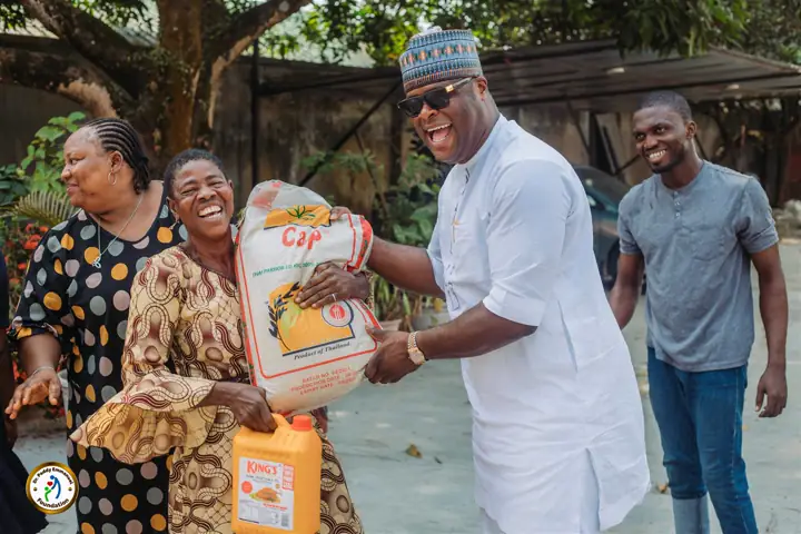 Dr Paddy Iyamu presenting a bag of rice to a beneficiary
