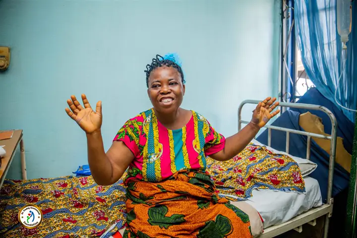 A patient smiling in her hospital bed